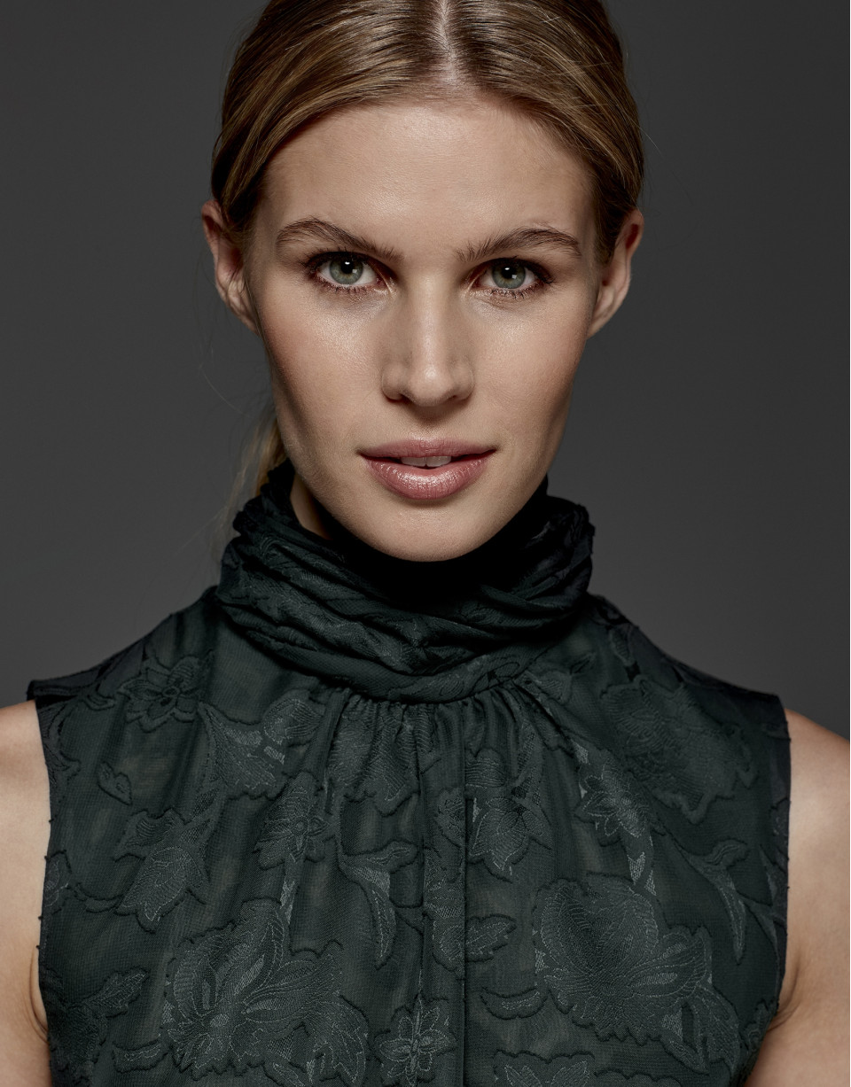 English green top with high draped collar