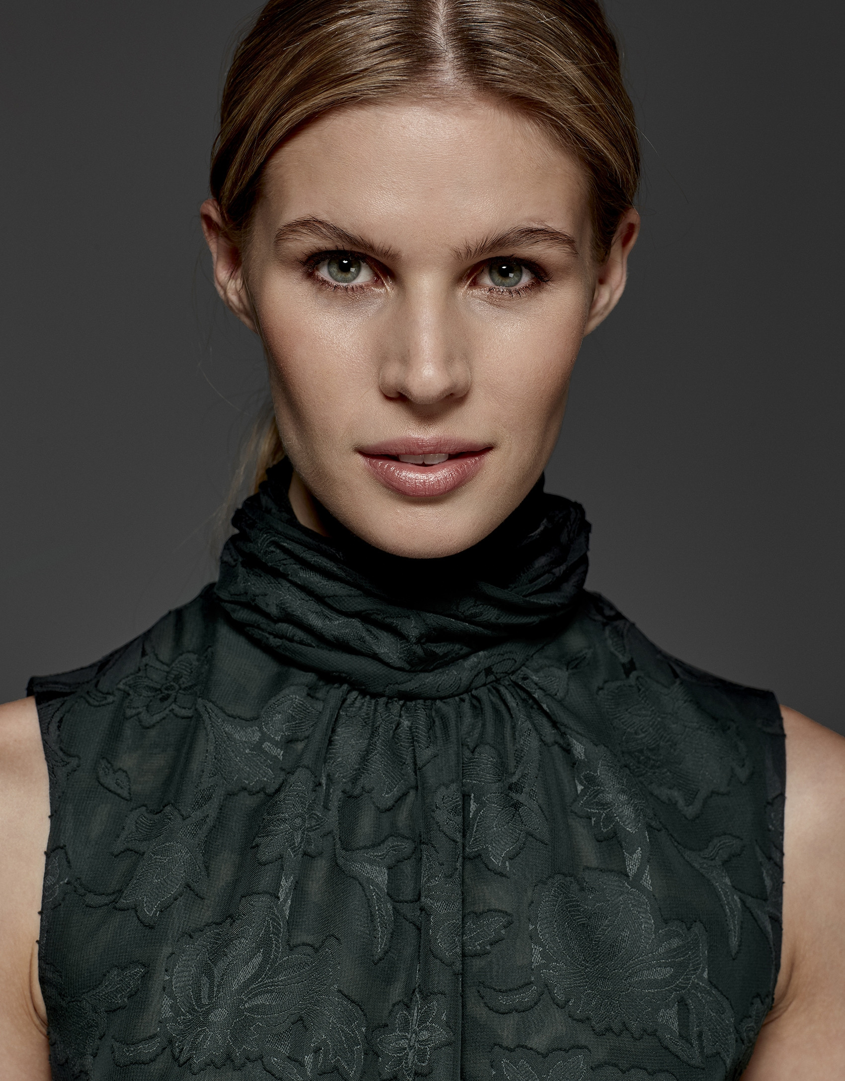 English green top with high draped collar