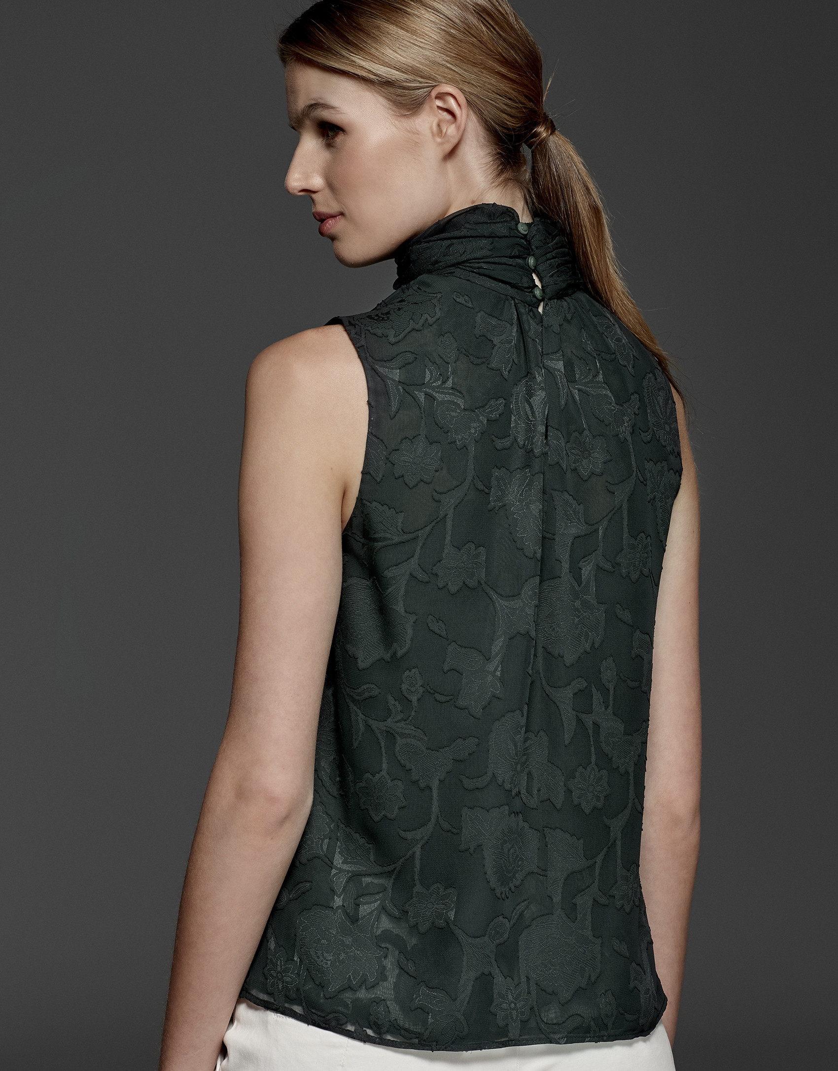English green top with high draped collar