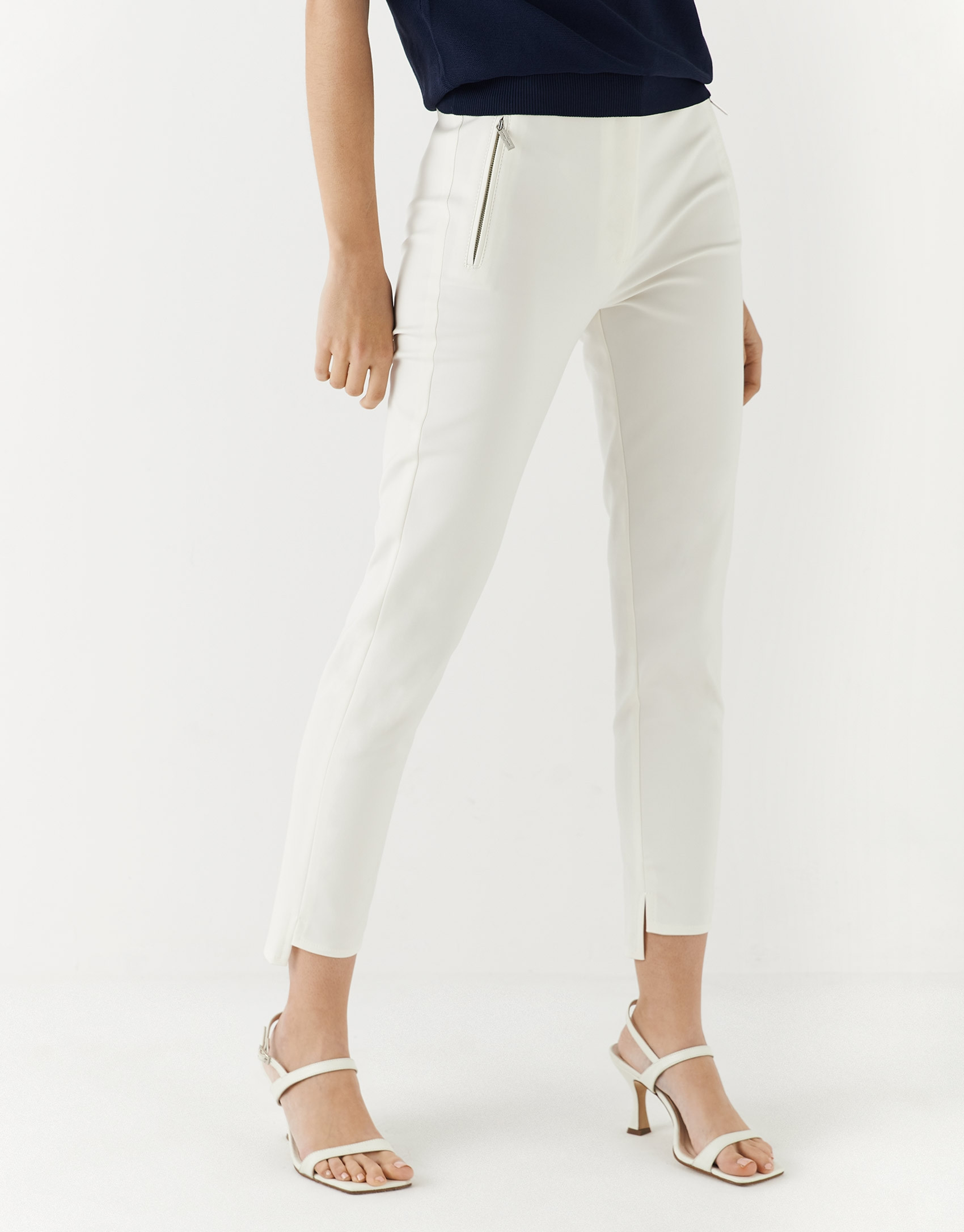 Beige colored fitted pants with zippered pockets