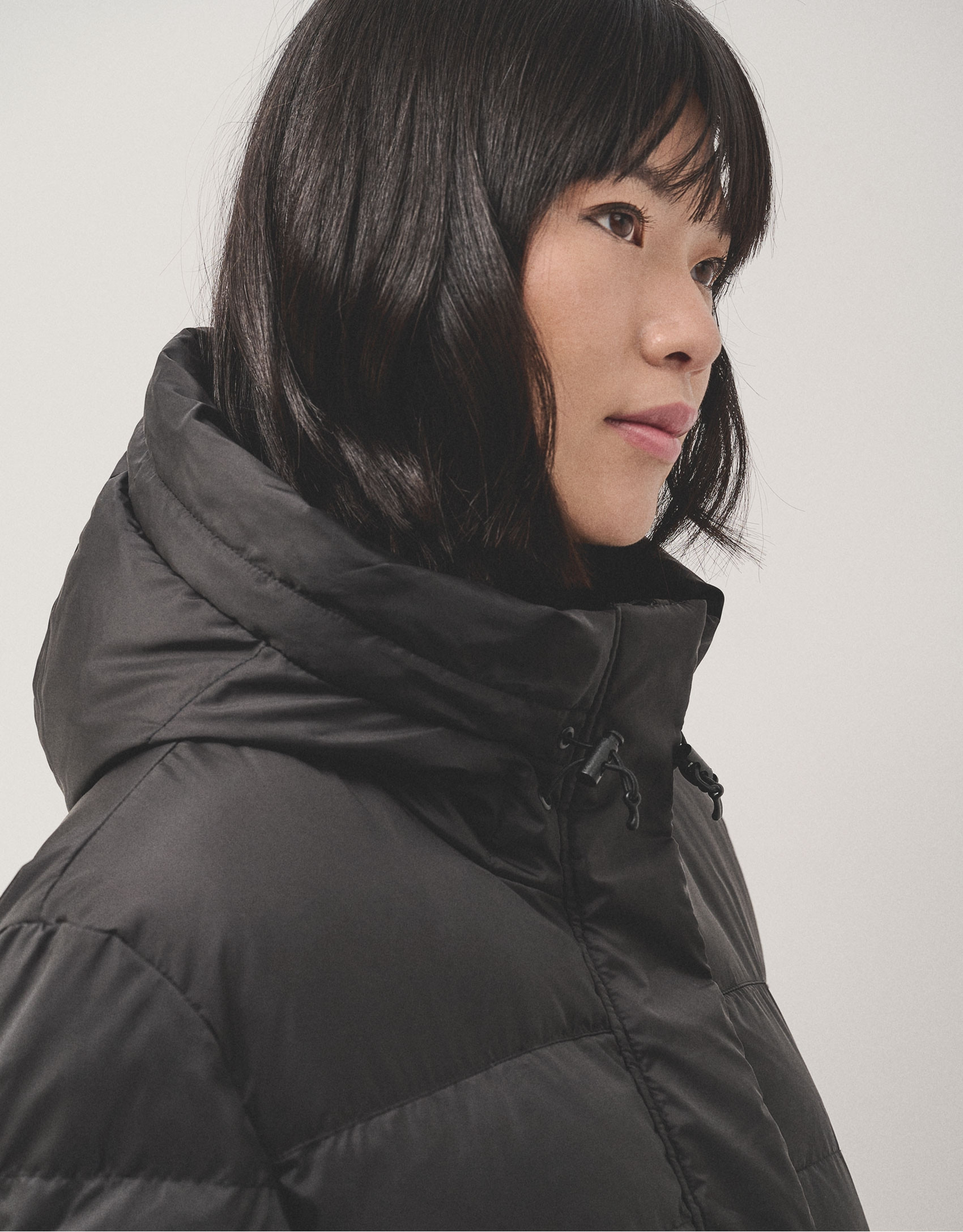 Long black quilted coat with beige interior | Roberto Verino