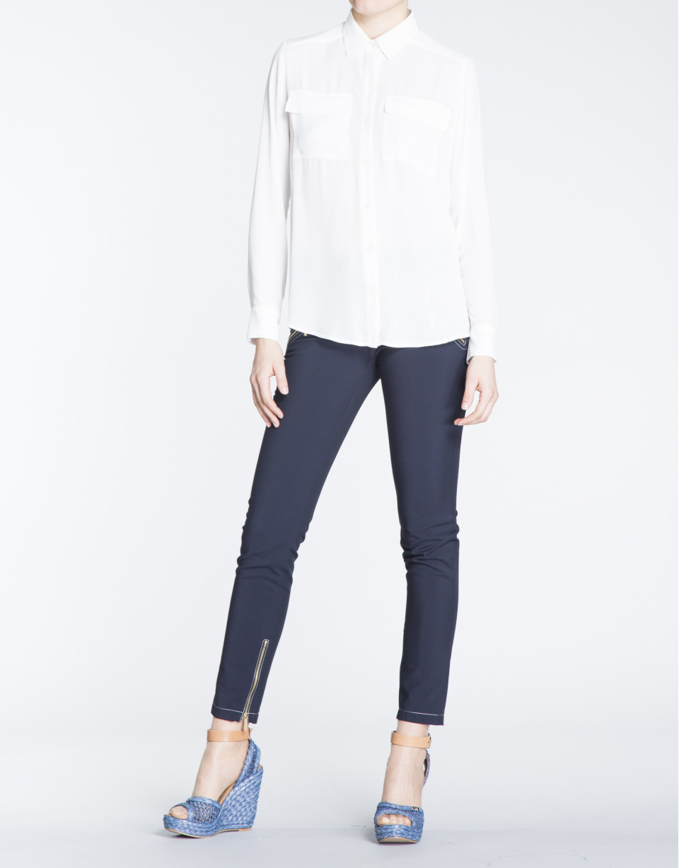 Camisa blanca de manga larga con bolsillos en delantero.