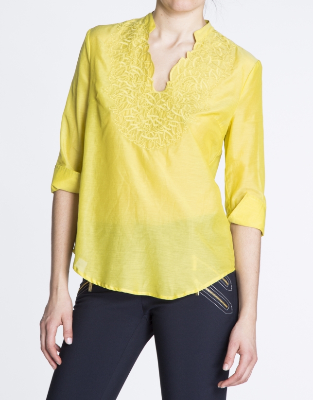 Blusa de seda amarilla con escote bordado a tono.