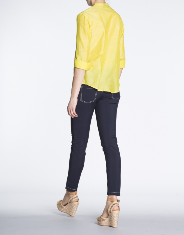 Blusa de seda amarilla con escote bordado a tono.