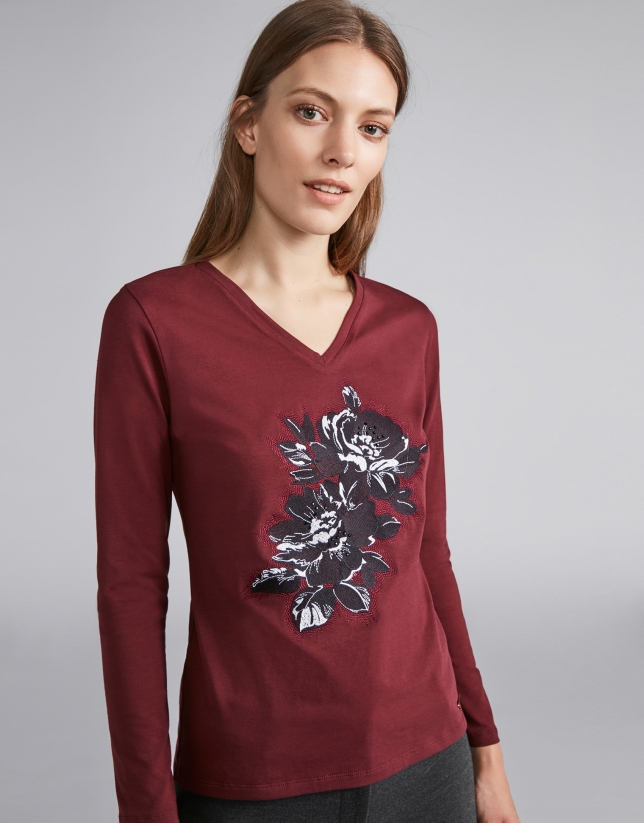 Camiseta cuello pico granate con flor bordada