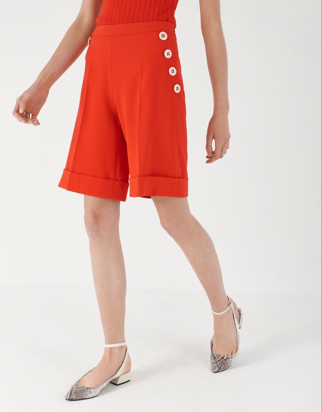 Red shorts with decorative row of buttons