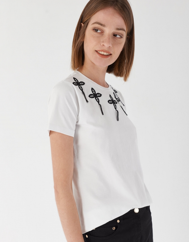Camiseta blanca con aplicaciones bordadas en escote