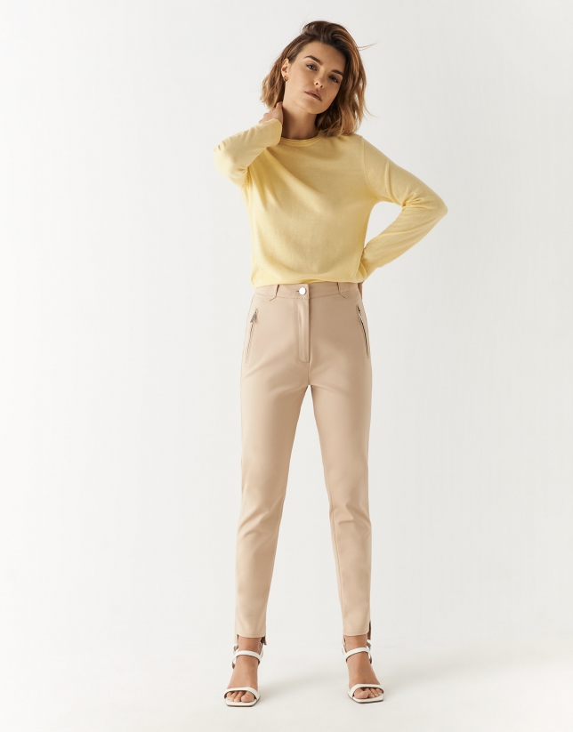 Cream colored fitted pants with zippered pockets