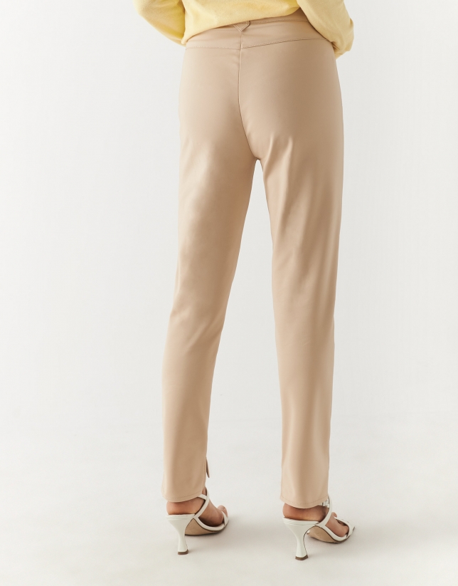 Cream colored fitted pants with zippered pockets