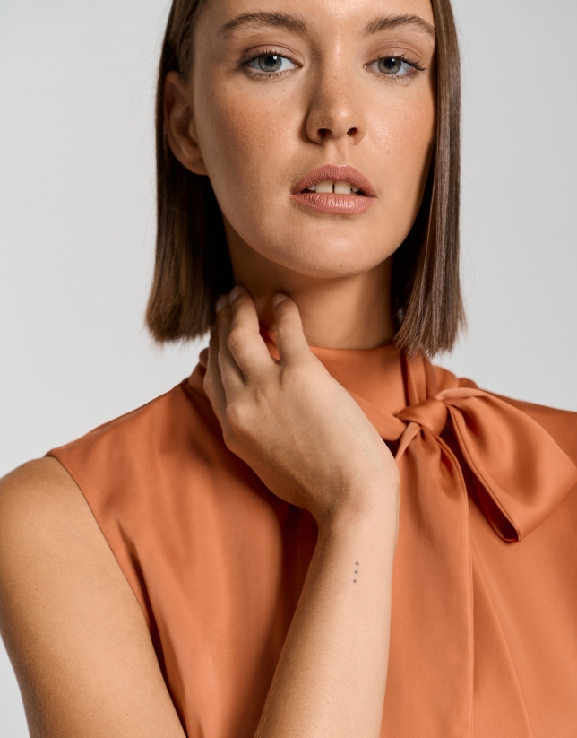 Orange satin knit top with bow