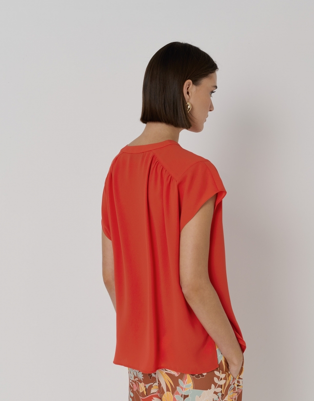 Red blouse with gathered yoke on shoulders