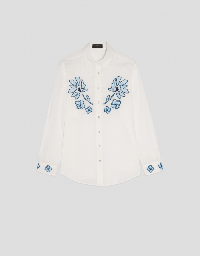 Camisa blanca con flores azules bordadas
