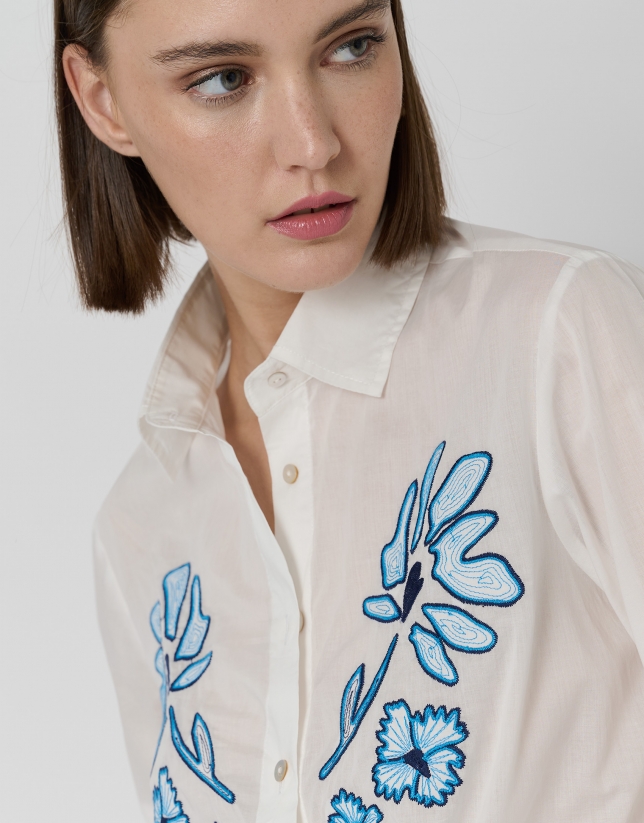 Camisa blanca con flores azules bordadas