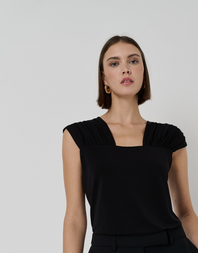 Black knit top with puckered shoulders